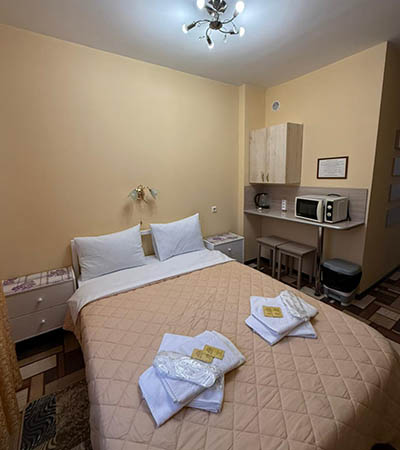 Семейный номер 35 м²  в отеле Турист, Луга - комната с большой кроватью, кухня